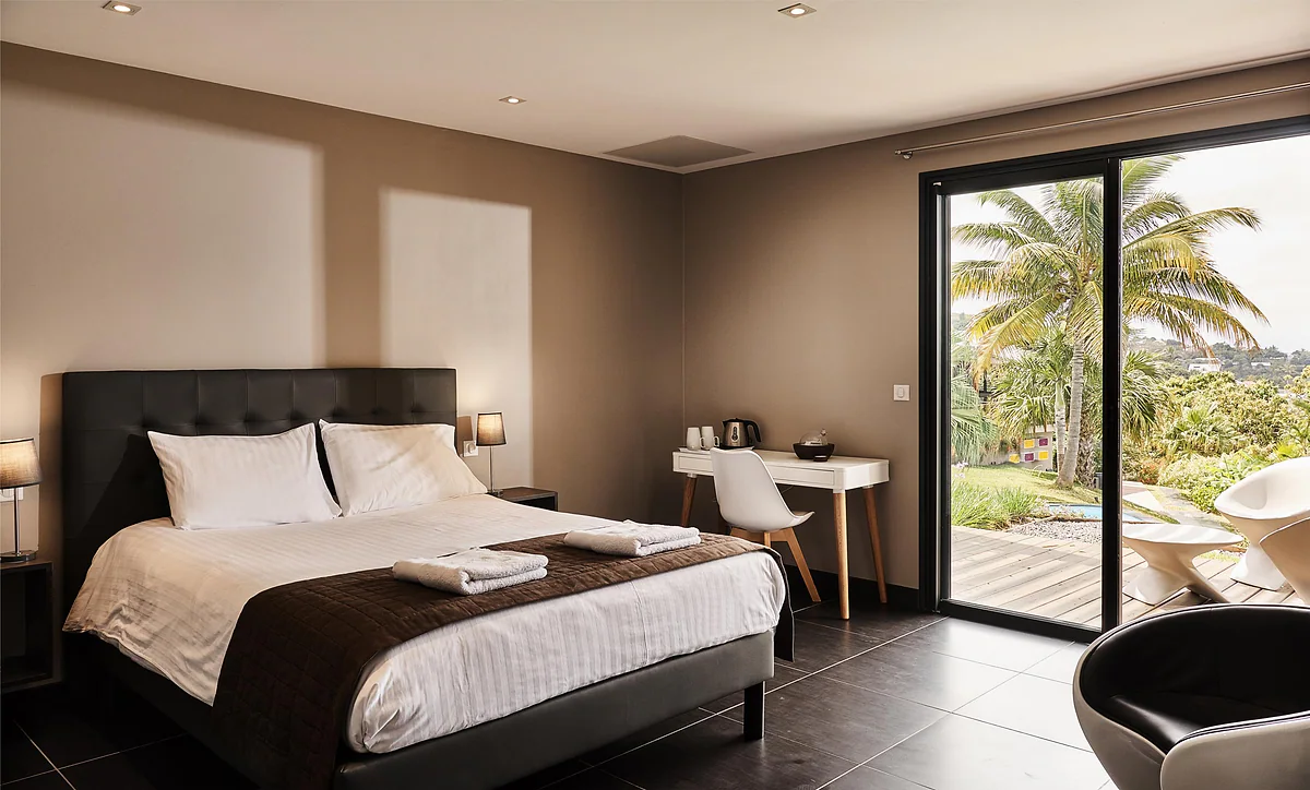 La chambre Géranium, son grand lit et la porte vitrée sur la terrasse