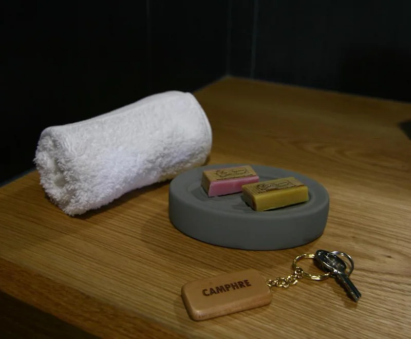 Une serviette roulée et la clé de la chambre Camphre