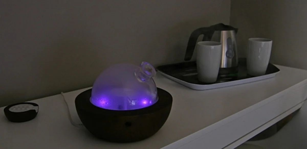 Le diffuseur d'huiles essentielles allumé, la bouilloire et les tasses sur le plateau