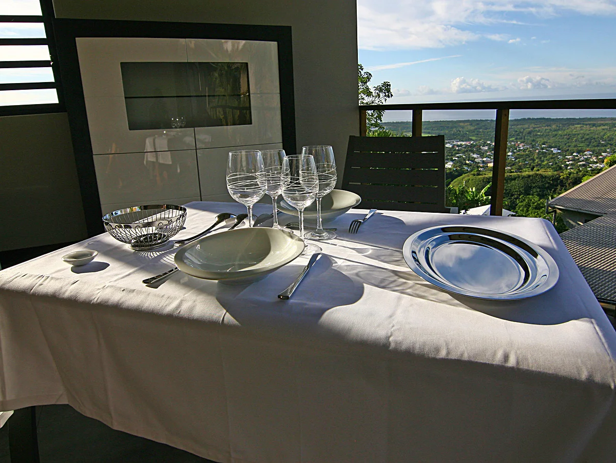 Une table dressée sur la terrasse, avec la vue sur la baie
