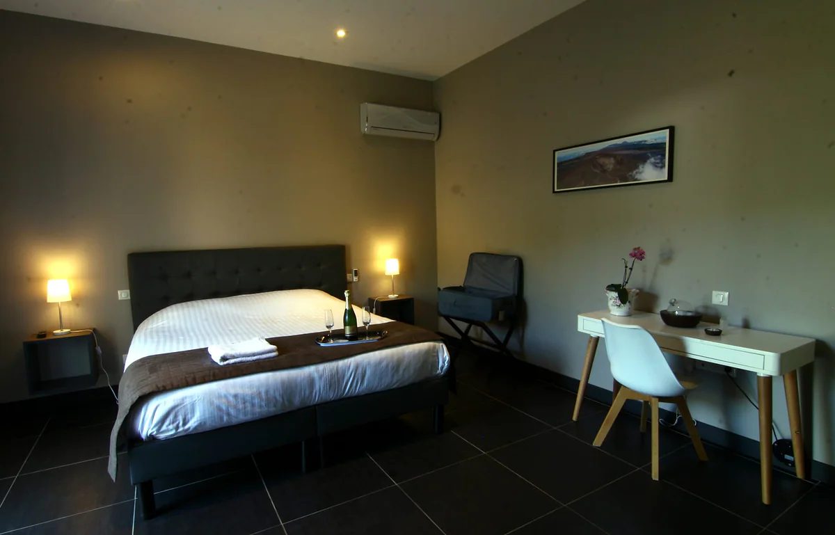 La chambre Ylang-Ylang, son grand lit, ses lampes de chevet et son bureau