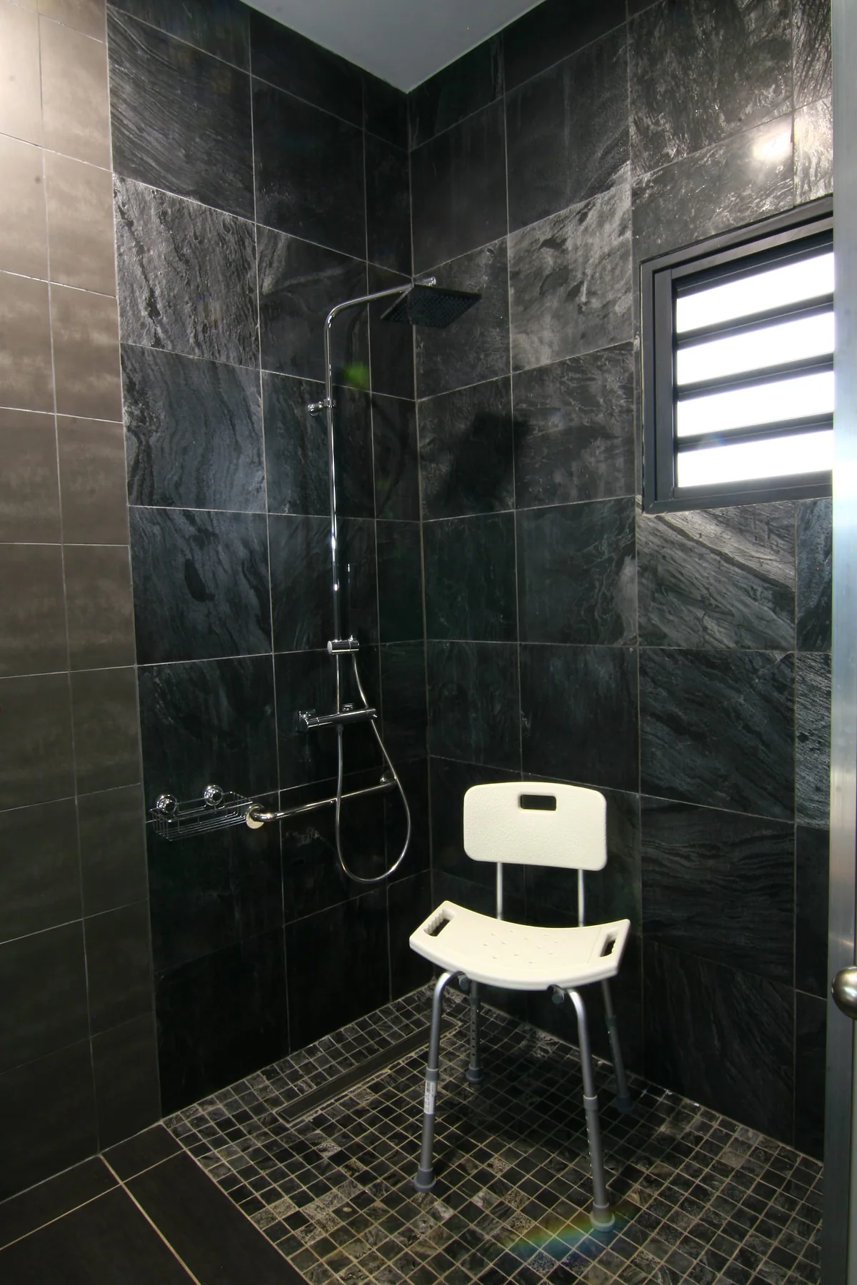 La douche à l'italienne de plain-pied, avec son siège de douche